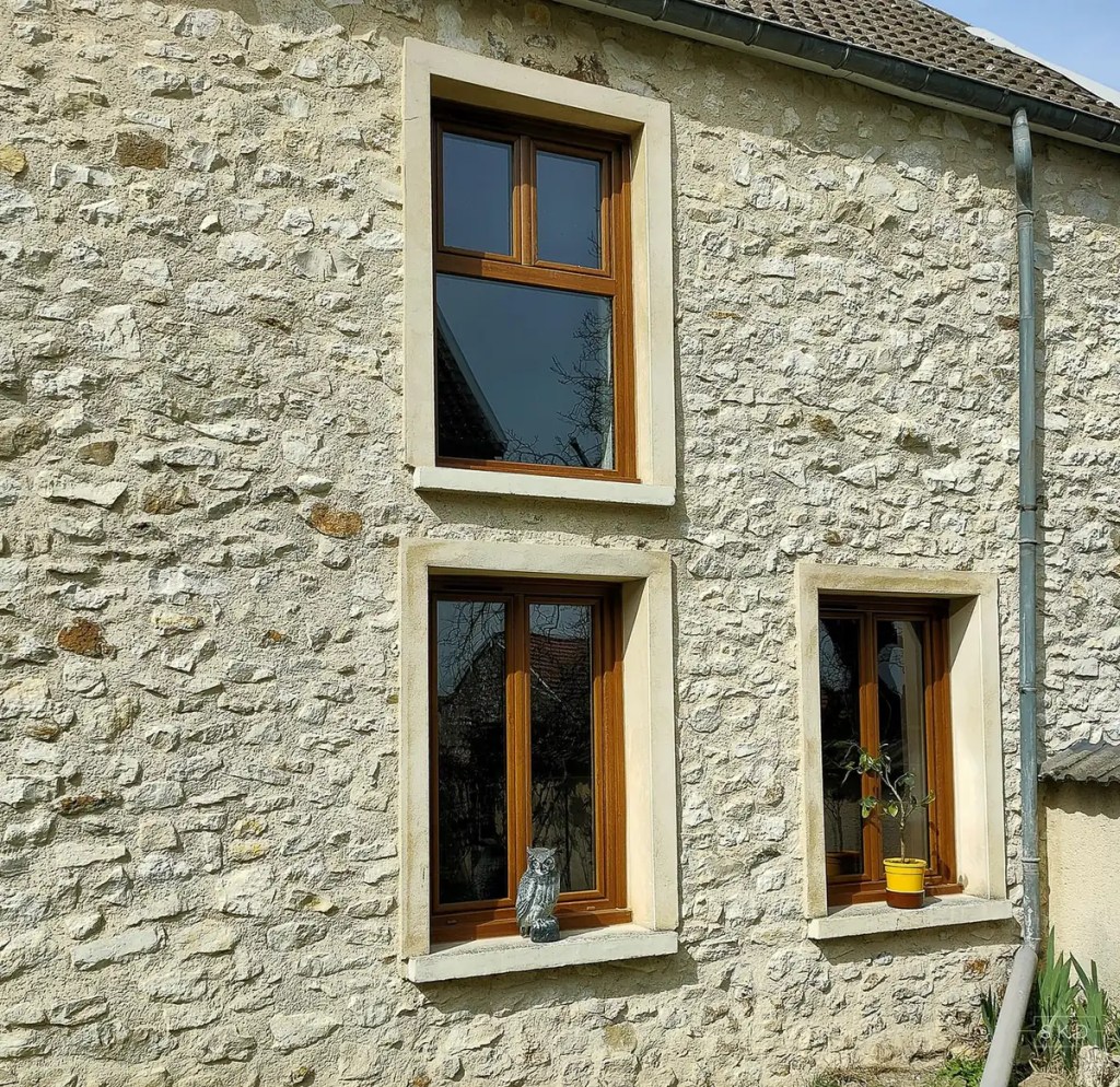 Fenêtres ton chêne sur une façade en pierre dans la Marne