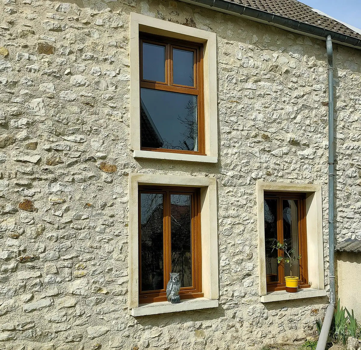 Fenêtres ton chêne sur une façade en pierre dans la Marne