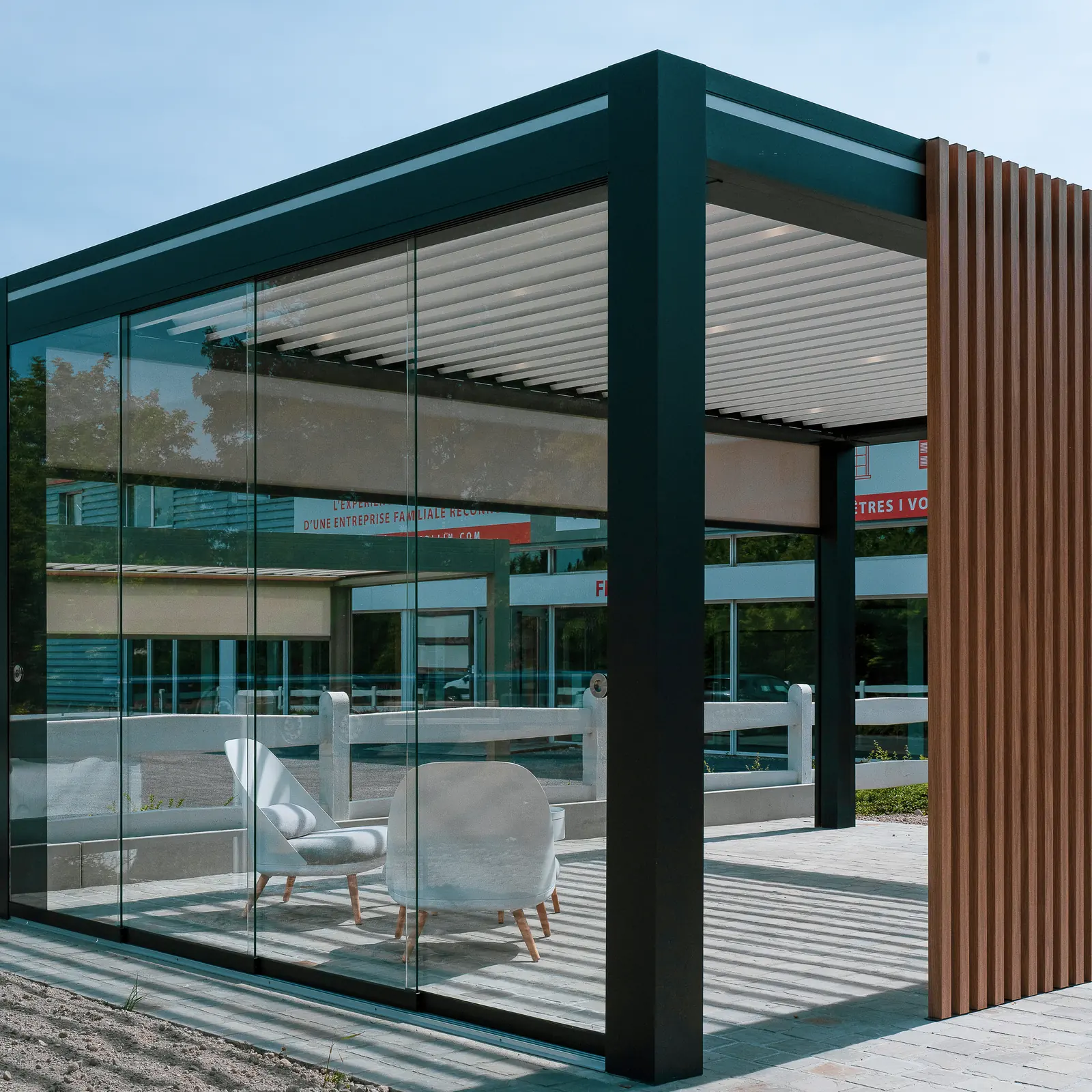 Pergola bioclimatique vitrée avec habillage bois au showroom de Cormontreuil