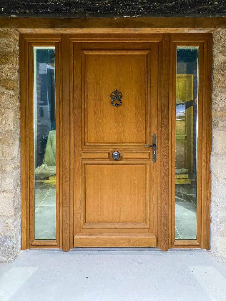 Porte d’entrée ton chêne avec fixes latéraux vitrés dans la Marne